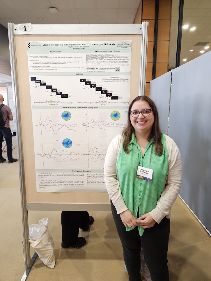 Image of the a researcher standing in front of a scientific poster with her work on bilingual children with DLD